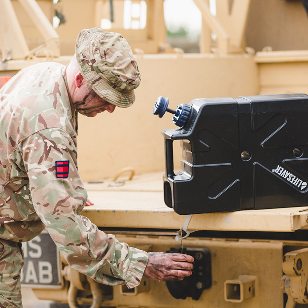 Load image into Gallery viewer, Soldier in camouflage uniform filling a cup from a black LifeSaver Jerrycan on a military vehicle
